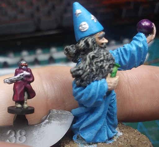 A 10mm Resistance Fighter held next to a 28mm Wizard